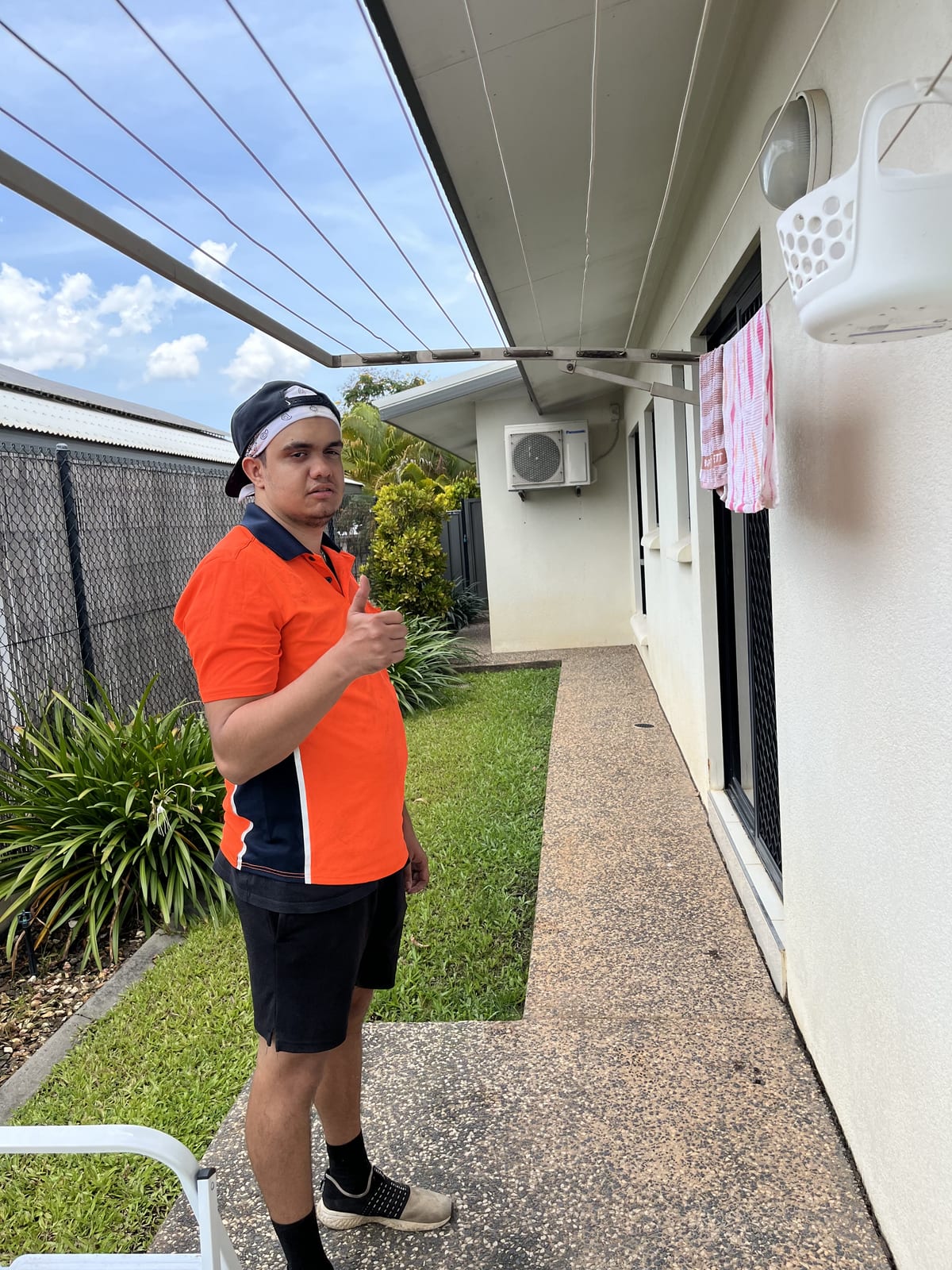 Participant giving a thumbs up outside their home in Darwin