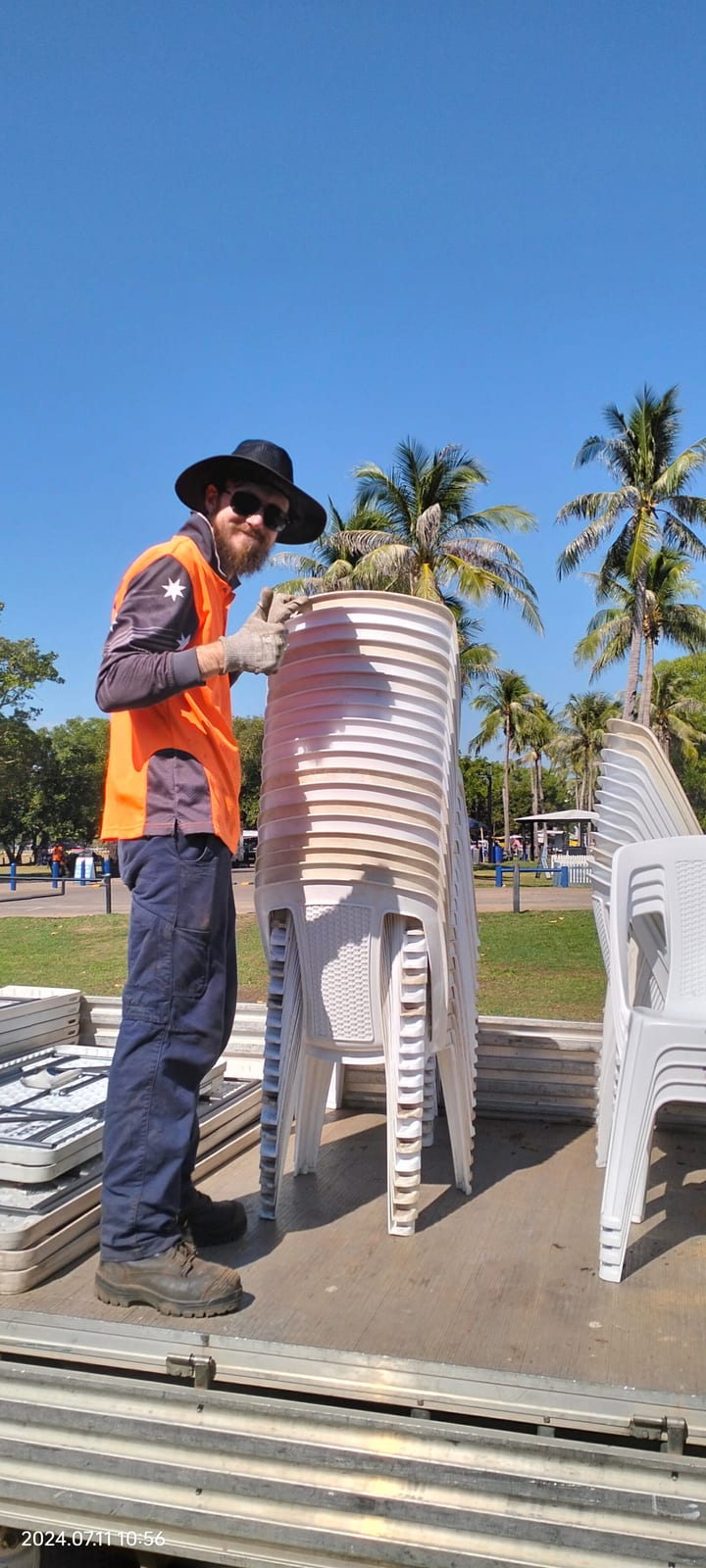 Participant stacking chairs while setting up a community event in the NT