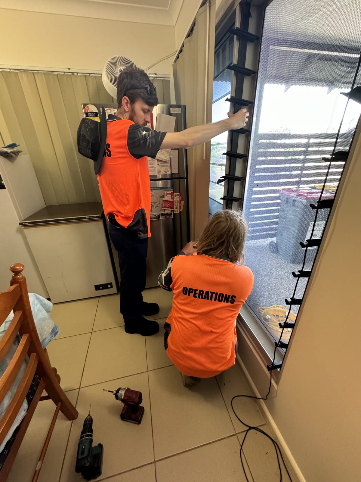 Participants installing fittings indoors as a team during supported work