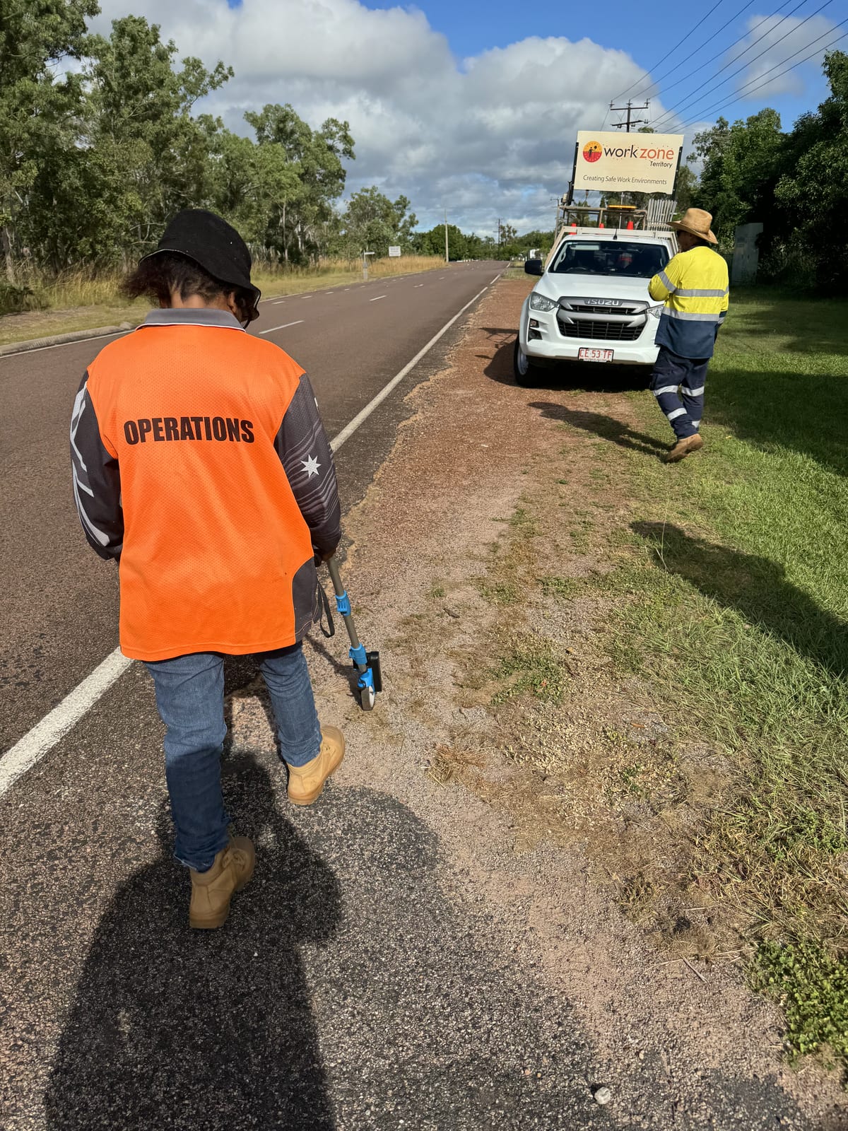 Participant walking a roadside worksite in the Top End during supported work